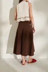 Falda larga de jean color marrón, de corte acampanado con costuras pespuntadas visibles y diseño de tiro medio.