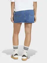 Falda mini de denim azul con diseño clásico de cinco bolsillos y cierre frontal con botones. Presenta las icónicas tres tiras de la marca en los laterales.