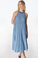 Vestido largo de tejido de punto, color celeste claro con rayas verticales en azul más oscuro y destellos de lurex. Presenta cuello halter y silueta en A, sin mangas.