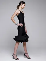 Vestido negro de cóctel con breteles finos y falda midi con volados.