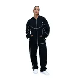 Campera deportiva unisex de color negro con cierre frontal completo y detalles de costuras en color blanco. Presenta capucha con cordones ajustables, bolsillos laterales y un diseño de líneas curvas que recorren el frente y las mangas.