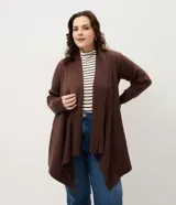 Cardigan de punto color marrón, con diseño alargado y puntas asimétricas. Presenta mangas largas, cuello tipo chal y detalles de textura canelada en los laterales.