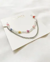 Set de collar de cuentas transparentes con dijes de corazones de colores y cadena de acero plateada.