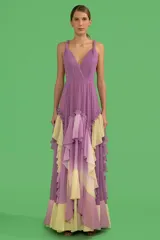 Vestido largo lila con degradé amarillo, de tirantes finos retorcidos, busto plisado, escote cruzado, espalda descubierta y falda con volados.