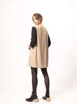 Vestido corto negro con mangas 3/4 verdes, cuello bote y bolsillos laterales.