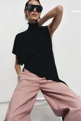 Pantalón de tiro medio confeccionado en piel 100%, con diseño de corte recto y costuras horizontales marcadas. Presenta cintura con trabillas, bolsillos laterales y cierre frontal con cremallera y botón.