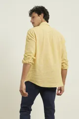 Camisa de manga larga confeccionada en una mezcla de algodón y lino, con cuello abotonado, cierre frontal de botones y un bolsillo en el pecho.