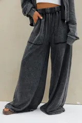 Pantalon de jogging negro con efecto acid wash, corte ancho y fluido, tiro alto con cintura elastizada fruncida y bolsillos frontales aplicados.