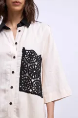 Camisa color crudo con cuello negro, mangas 3/4 y aplique de crochet negro en el frente.