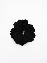 Colita para el pelo tipo scrunchie de color negro, con diseño voluminoso y bordes con volados.
