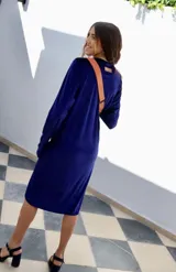 Vestido azul de terciopelo, largo hasta la rodilla, con mangas largas y corte ajustado.