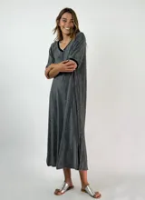 Vestido midi color gris oscuro con brillo, escote en V con ribete negro y blanco, mangas cortas y aberturas laterales en el dobladillo.