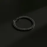 Pulsera de eslabones tipo cubana en acero color negro, con cierre de mosquetón.