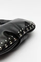 Cartera hobo negra de símil cuero con tachas metálicas plateadas.