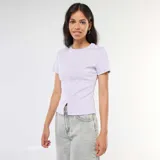 Camiseta lisa color lila de punto de canalé fino, con cuello redondo y mangas cortas.