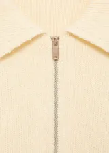 Cardigan de punto color crema con cuello camisero, cierre frontal de cremallera y cinturón integrado con hebilla a la cintura.