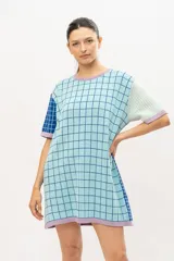 Vestido tipo remerón tejido en algodón con diseño a cuadros en tonos celeste, azul y lila.