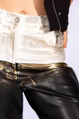 Pantalón de jean de tiro alto con corte recto, con parte superior de jean blanco y parte inferior de cuero sintético negro con efecto dorado.