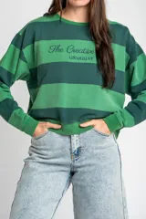 Sweater de algodón peinado con diseño de rayas horizontales en tonos verde oscuro y verde claro, de corte holgado y manga larga, con detalle de bordado en el pecho.