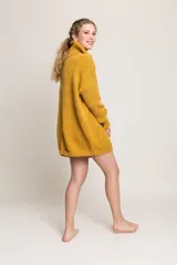 Sweater mostaza de lana merino con cuello alto y bolsillos delanteros. Diseño holgado y atemporal.