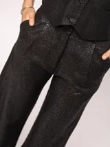 Pantalón de lino color beige, de tiro alto, pierna ancha y levemente acampanada. Tiene pinzas delanteras, elástico en la pretina trasera, cierre delantero y broche interno, bolsillos laterales y dobladillo invisible.