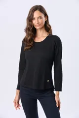 Remera de manga larga con cuello redondo, confeccionada en tejido de algodón. Presenta un corte clásico y un pequeño aplique metálico decorativo en el ruedo.