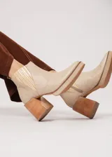 Botín de cuero color beige con textura reptil, elástico lateral y cierre interno. Tiene plataforma delantera y taco de madera.