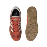 Zapatillas Adidas Handball Spezial color naranja con detalles en blanco y suela color caramelo.