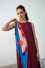 Pañuelo liviano y translúcido de forma romboidal, con diseño estampado inspirado en un atardecer, en tonos naranja, bordó, rosa y azul.