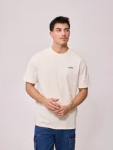 Remera de algodón con lavado, color crema o blanco roto, de corte regular fit y manga corta. Presenta un pequeño logo bordado en el pecho.