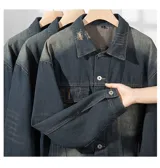 Campera de jean azul oscuro con corte boxy y efecto desgastado. Presenta detalles de roturas, cuello clásico, cierre frontal con botones metálicos y bolsillos de parche con solapa en el pecho.