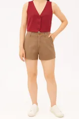 Short de jean color beige, de tiro alto, con bolsillos laterales y cierre frontal con botón.