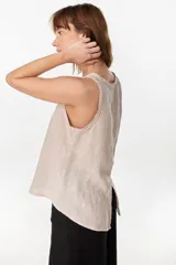 Blusa marrón de lino, sin mangas, con escote redondo y corte evasé. Presenta una costura vertical central en el frente y bajo asimétrico.