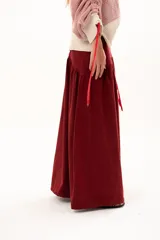 Pollera larga de corte recto con detalle de volado en la parte inferior, confeccionada en tela color bordó.