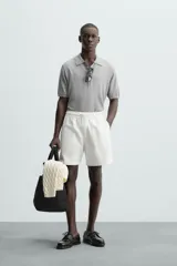 Bermuda de algodón color beige claro, de corte regular fit, con cintura elástica ajustable mediante cordón. Presenta bolsillos laterales y un bolsillo trasero de vivo.