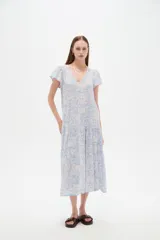 Vestido midi de viscosa con estampado floral en tonos celeste y blanco, cuello en V, mangas cortas y diseño holgado con volados escalonados en la falda.