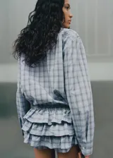 Camisa oversize de algodón con estampado a cuadros, cuello camisero, cierre frontal de botones y mangas largas.