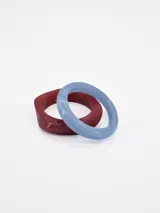 Set de dos pulseras rígidas de resina con efecto marmolado, una en tono rojo burdeos y otra en celeste.