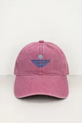 Gorro con visera rosado estilo dad hat, con efecto lavado y bordado frontal en tonos azules que representa un sol y líneas horizontales.