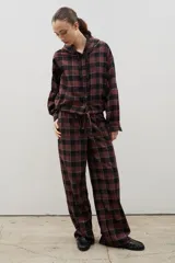 Pantalón de corte amplio y tiro medio-alto, confeccionado en tejido liviano con estampado a cuadros. Presenta cintura elastizada con lazo regulable y bolsillos laterales.