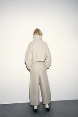 Pantalón de tiro alto con cintura elástica ajustable mediante cordón. Presenta un corte recto y holgado con bolsillos laterales y traseros.