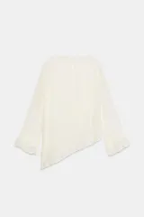 Blusa marrón de cuello redondo y manga larga, con volantes horizontales superpuestos y bajo asimétrico. Cuenta con detalle de abertura y botón en la espalda.