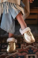 Pantuflas doradas con interior de corderito.