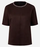Remera de corte regular confeccionada en gamuza sintética color negro, con mangas cortas y cuello redondo decorado con una aplicación de pedrería brillante.