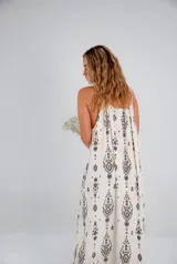 Vestido largo de tirantes color crudo con estampado de mandalas en negro y detalle de cordón ajustable en el escote.