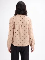 Blusa de algodón color bordó con estampado de lunares claros, cuello mao, cierre frontal con botones y mangas largas.