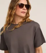 Remera oversized gris de mangas cortas, confeccionada en algodón peruano, con cuello redondo y diseño liso sin estampa.