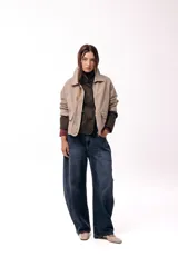 Campera corta color marrón, con cuello alto estructurado, cierre frontal y bolsillos delanteros con solapa. Presenta puños y cuello en tejido acanalado, con un diseño de corte recto y minimalista.