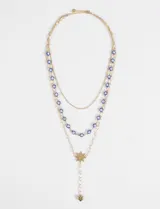Collar tipo cascada de dos niveles con cadena dorada, decorado con cuentas de ojitos turcos azules y un dije central en forma de estrella con un pequeño corazón colgante en el extremo inferior.