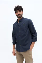 Camisa de gabardina azul marino con efecto stone wash, doble bolsillo frontal con solapa y botón, y fit regular.